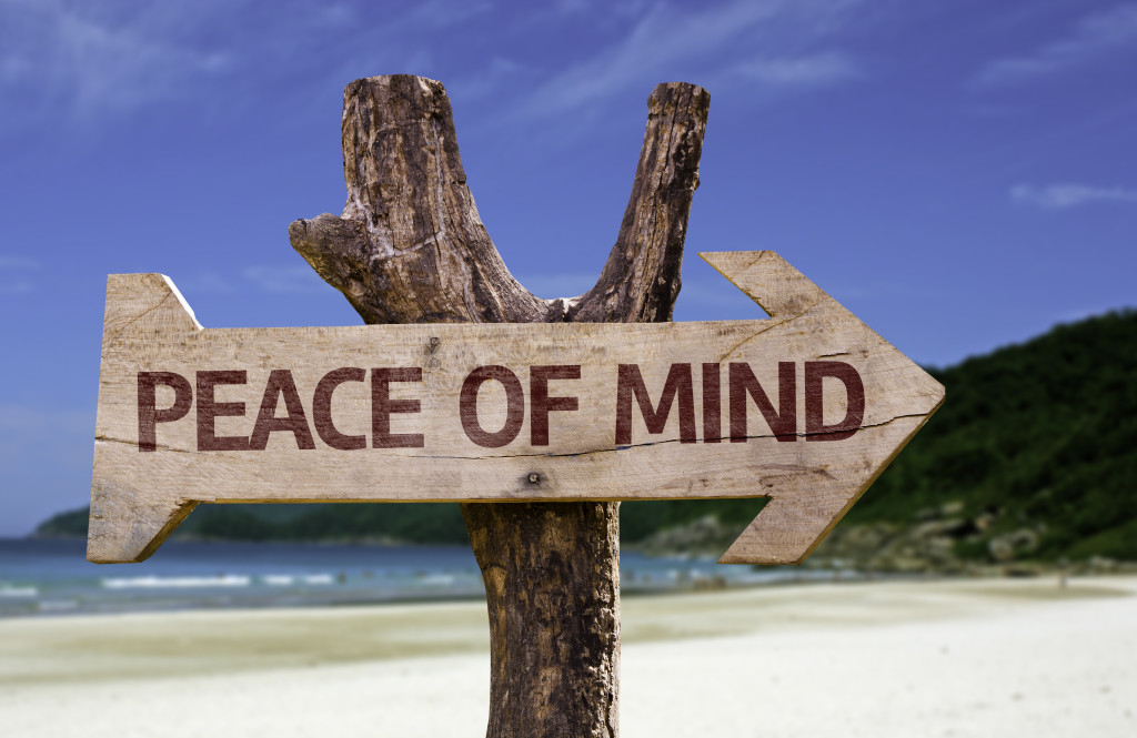 Peace of Mind wooden sign with a beach on background